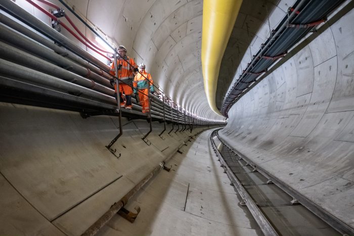 Photo of the inside of a tunnel with 2 operators walking inside